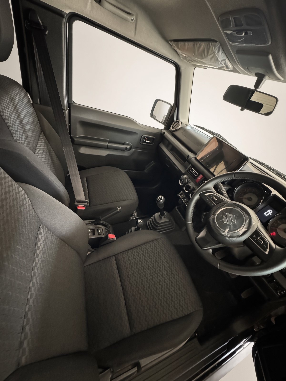 Driver’s seat, still with factory plastic on the wheel